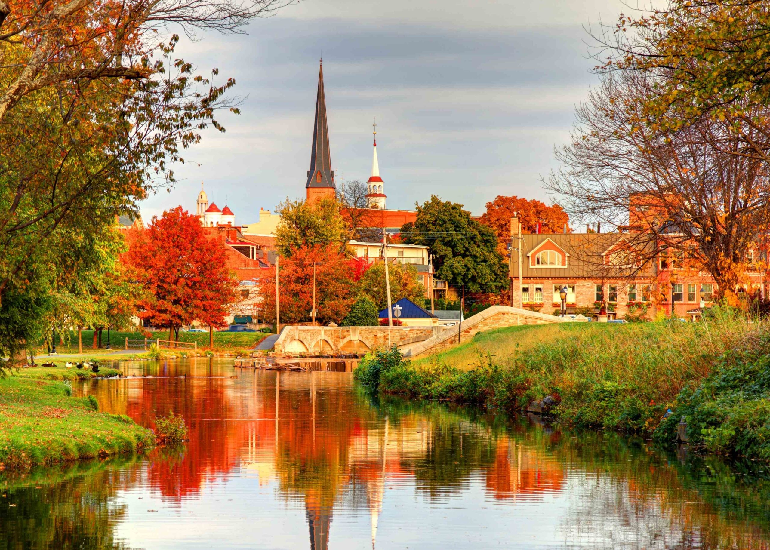 Sunset view of Downtown Frederick, Maryland skyline as seen from on Carroll Creek, surrounded by fall foliage
