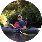 Profile picture of a testimonial - a man with sunglasses and hat smiling while rowing a kayak
